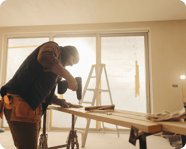 Construction worker drilling indoors